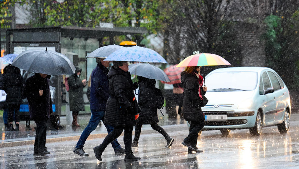 Varias personas con paraguas pasan por un paso de cebra, a 16 de enero de 2023, en Santander