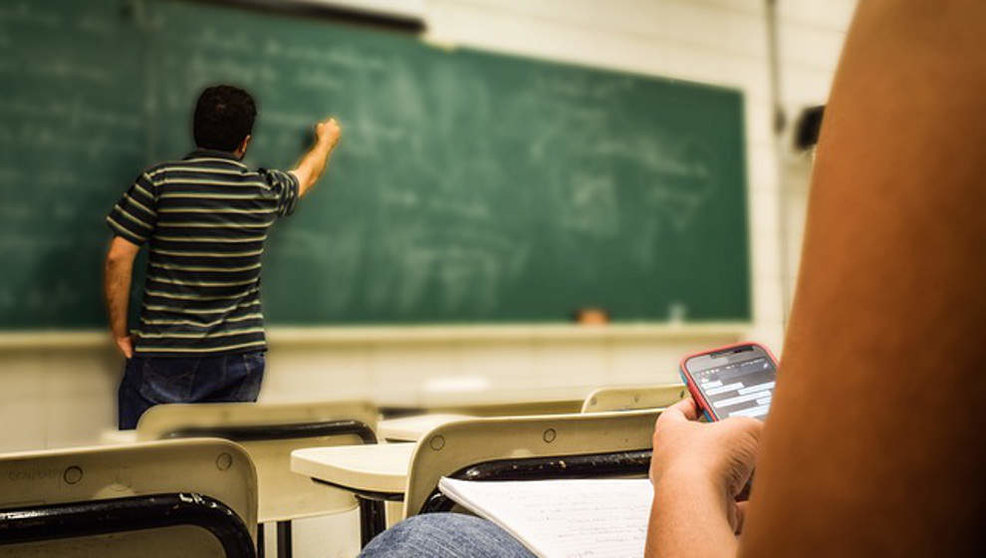 Un alumno utiliza un móvil en clase | Foto: Pixabay
